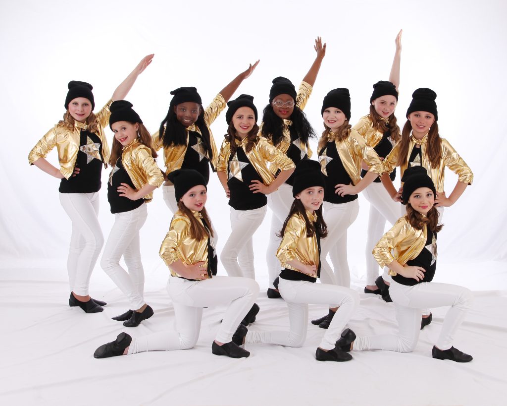 Jazz dancers in white pants and gold jackets