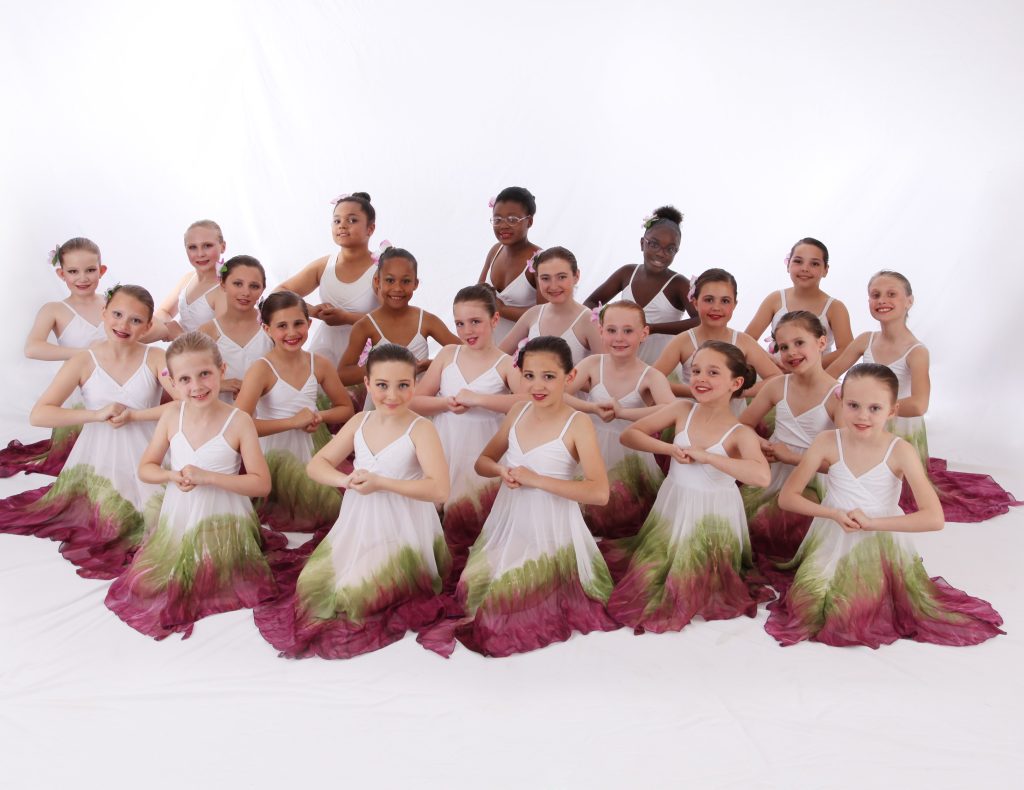 ballet dancers posing while holding hands in watercolor dresses