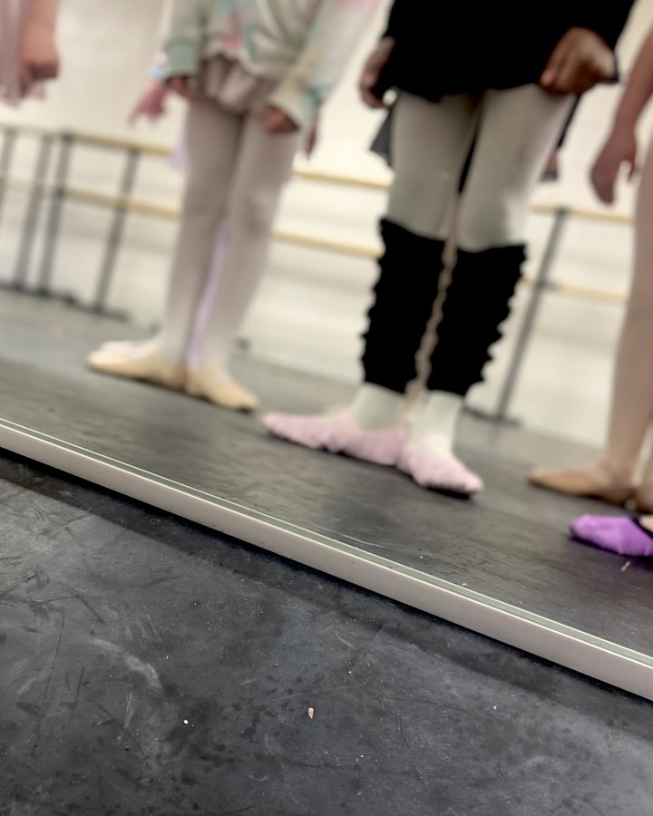 ballet dancers showing off their shoes in the mirror