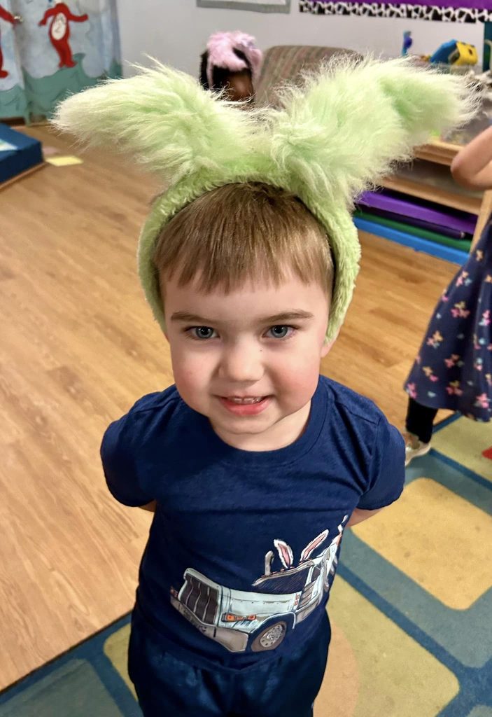 a boy wearing green bunny ears in preschool dance class